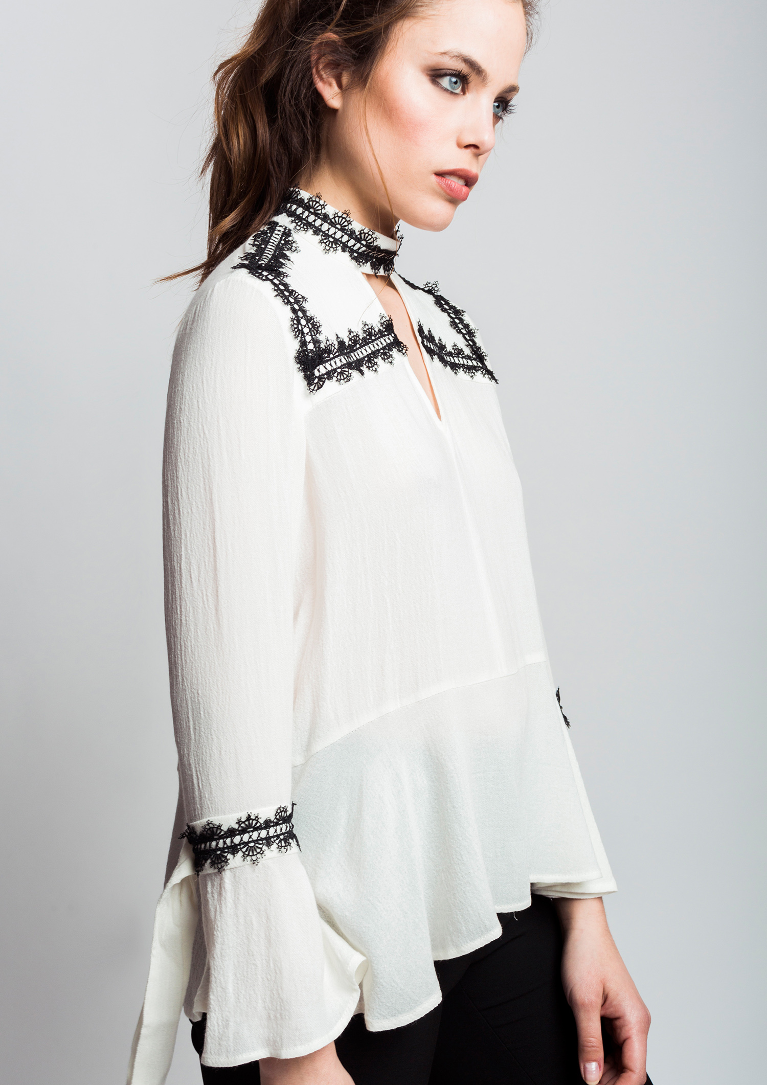 Ecru blouse with contrast lace trim.