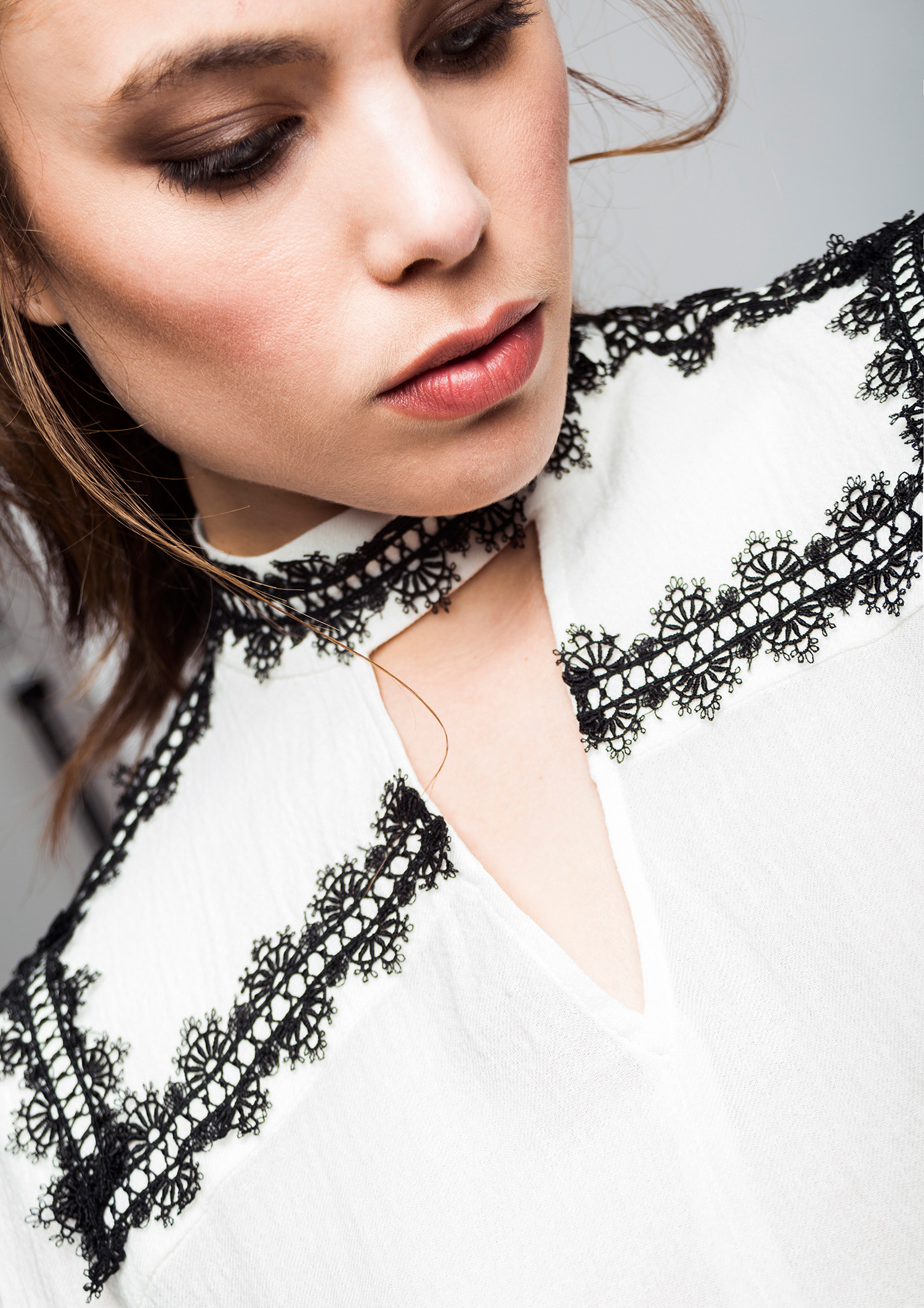 Ecru blouse with contrast lace trim.
