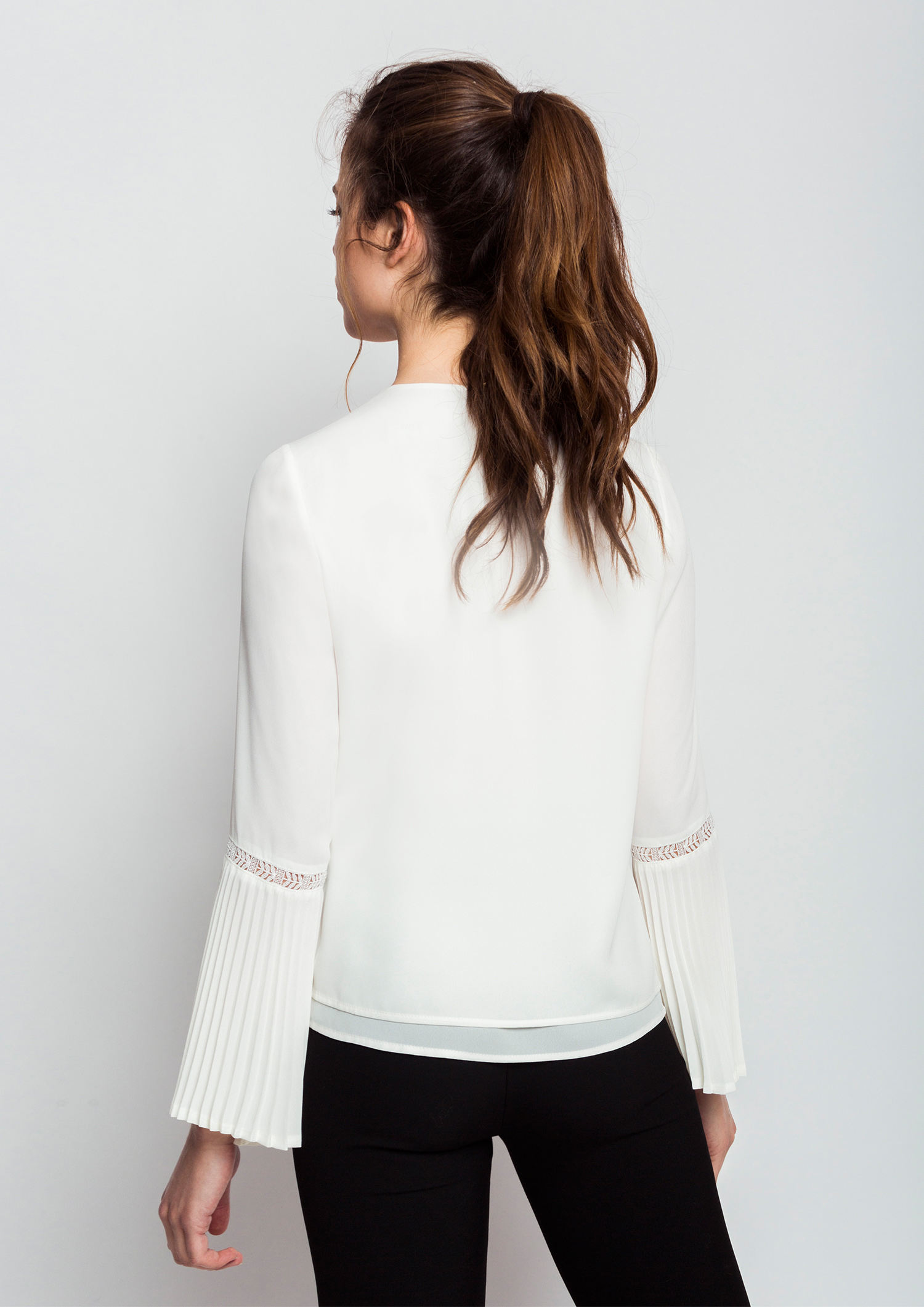 Ecru blouse with pleated sleeves.