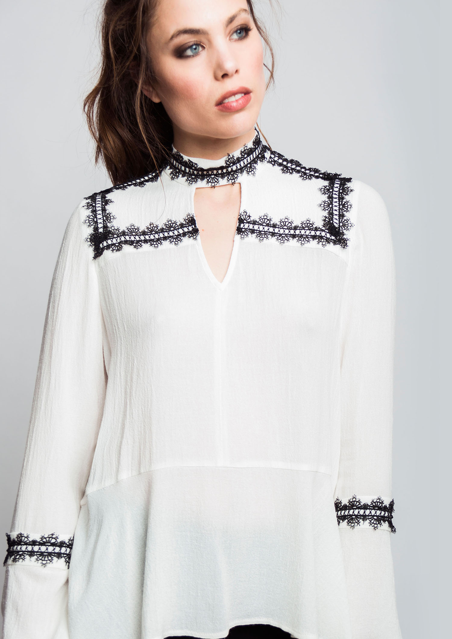 Ecru blouse with contrast lace trim.