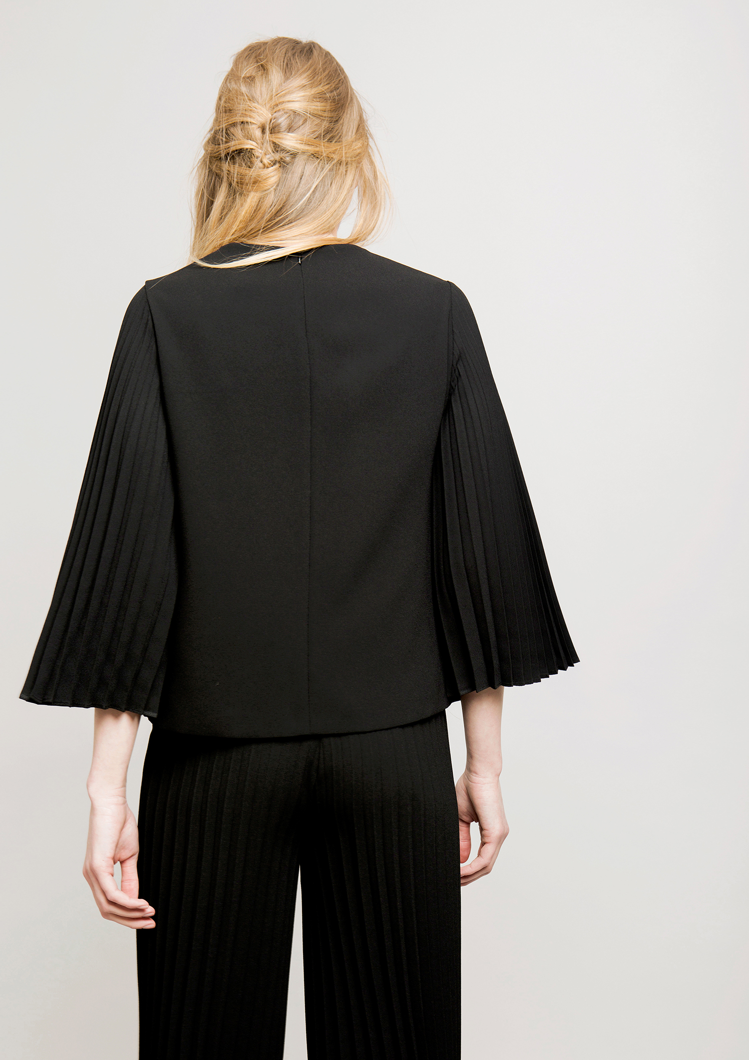 Black top with pleated sleeves.
